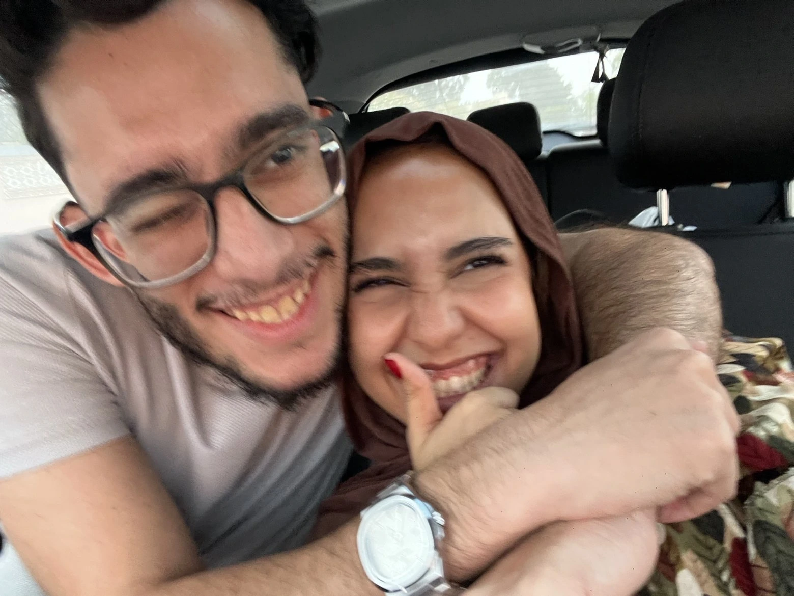Houssem and Rania laughing together in the car